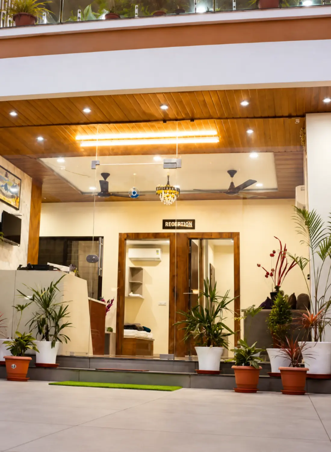The Shivkunj entrance with potted plants and a wooden ceiling