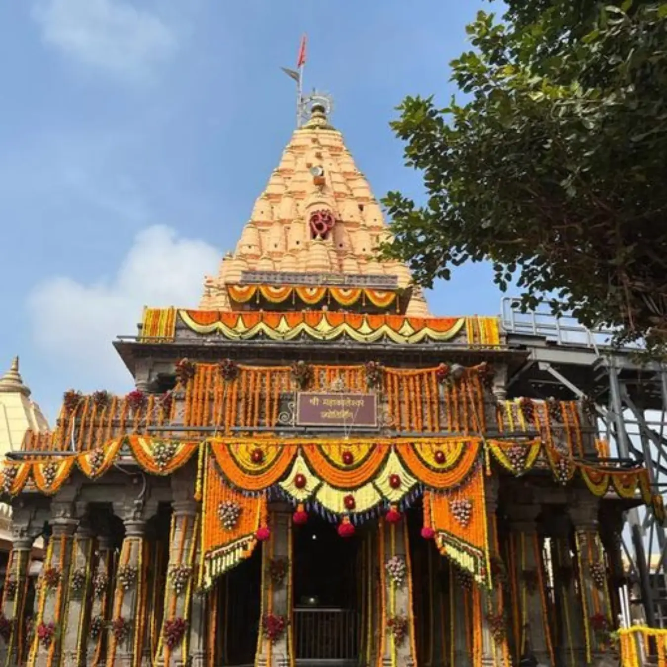 Decorated shikhara of the Mahakaleshwar temple against a blue sky