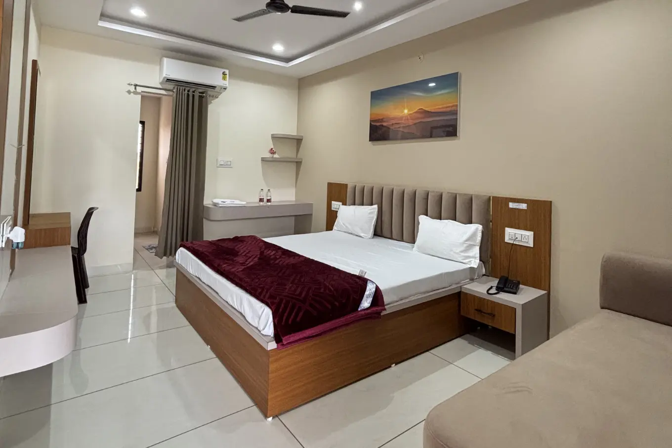 Spacious room with a large bed, built-in seating and a work table