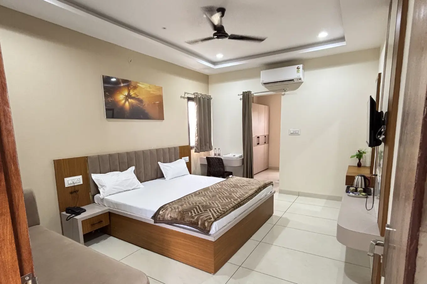 Room with king-size bed, wall-mounted TV and air conditioner