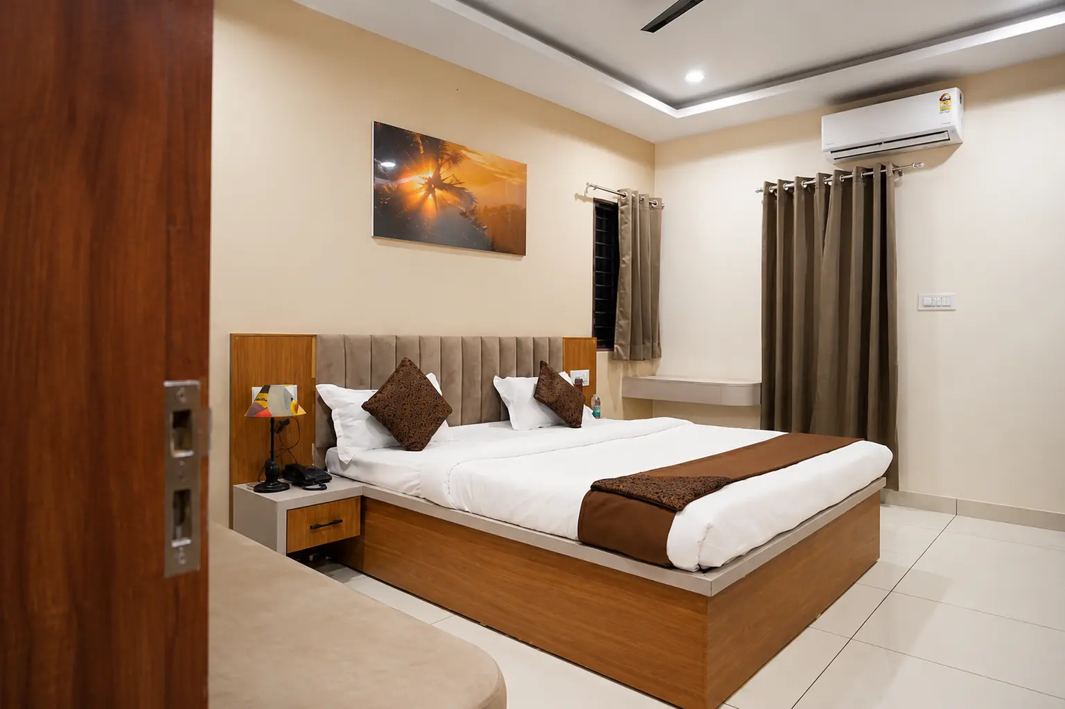 A guest room at Shivkunj, Ujjain, with a double bed, cushions and warm lighting